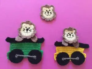 Finished crochet lion group on a pink background
