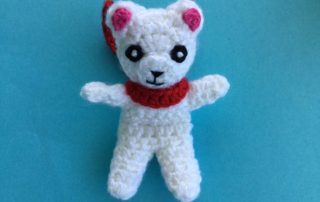 Finished crochet teddy for plane mobile with scarf landscape