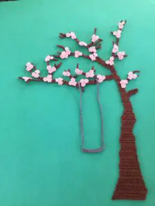 Finished crochet blossoms and swing blue background portrait