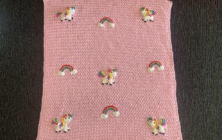 Finished crochet unicorn baby blanket landscape